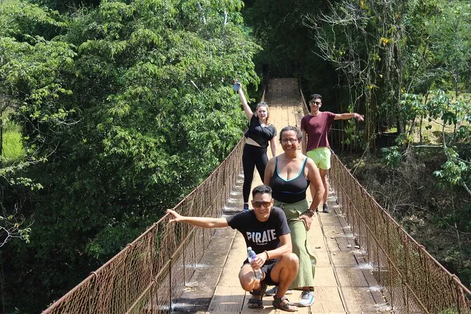 Small group walking through a Q'eqchi' Maya village on jungle paths near Semuc Champey Guatemala, cultural tour with local guide